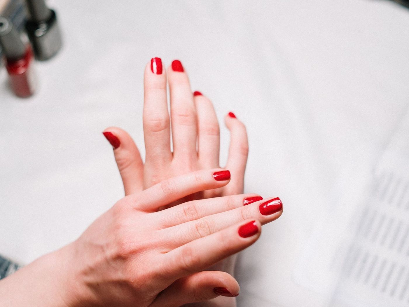 Manucure en cours : les mains d’une cliente posées sur la table de l’onglerie.